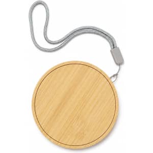 A round wireless charger set with a bamboo surface and a grey strap for easy carrying.