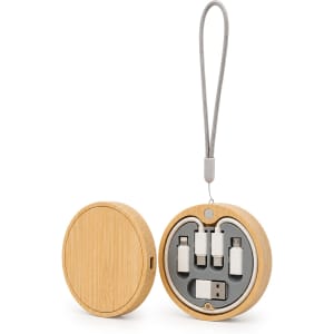 A round wooden wireless charger set in natural bamboo colour, containing various charging cables and a strap.