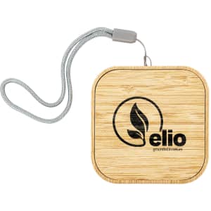 A square bamboo wireless charger with a silver strap and a logo.