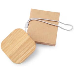 A square bamboo cable organiser with a silver strap, alongside a kraft paper packaging box.