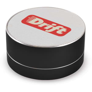 A round black Bluetooth speaker with a silver rim and a white top featuring a logo.