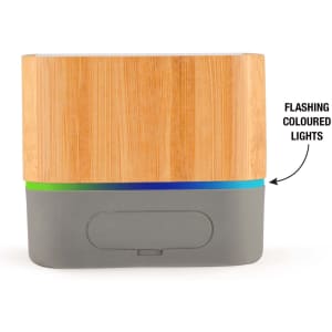 A bamboo Bluetooth speaker with a grey base, featuring a strip of flashing colored lights at the bottom.