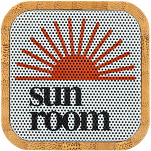 A bamboo Bluetooth speaker with a circular design featuring an orange sun graphic and 'sun room' text.