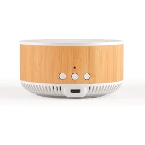 A round speaker and wireless charger in natural wood and white, featuring control buttons and a USB-C port.