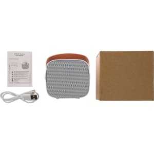 A mini speaker in gray and tan, accompanied by a charging cable, user manual, and a cardboard box.