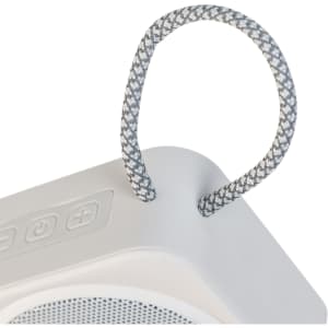 A white mini speaker with a grey braided handle and control buttons on top. It features a logo on the side.