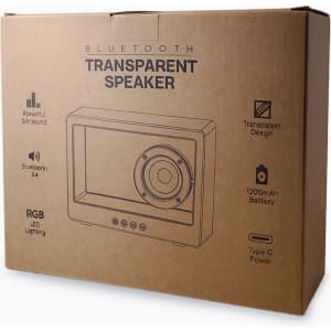 A cardboard box containing a transparent speaker with RGB LED lighting. It features icons for Bluetooth and power.