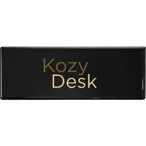 A sleek black desk with a gold logo featuring the text "Kozy Desk."