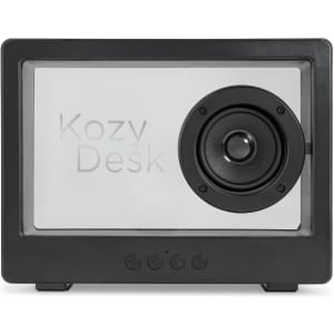 A black speaker with a prominent circular speaker and a transparent front, featuring branding and control buttons at the bottom.