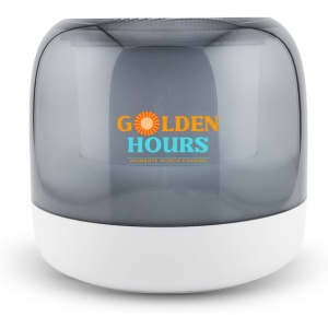 A compact speaker featuring a grey translucent cover and a white base, with branding on the front.