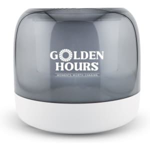 A grey and white speaker with a rounded design and a logo on the front.