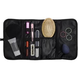 A black toiletry organizer featuring various compartments, a hairbrush, hair ties, and beauty accessories.