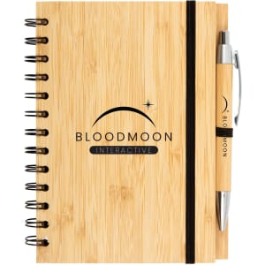 A bamboo notebook featuring a black spiral binding and an elastic band, accompanied by a matching pen.