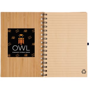 A spiral-bound A5 notebook with a bamboo cover, featuring a logo on the front and blank lined pages inside.