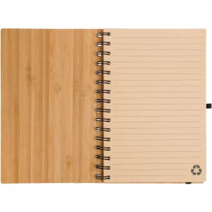 An A5 spiral notebook with a bamboo cover and lined pages, featuring a recycling logo at the bottom.