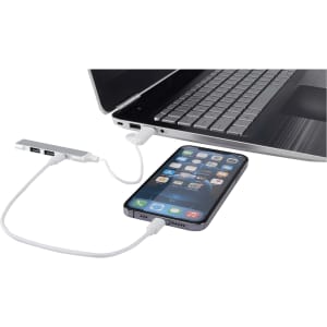 A 4-port USB hub in silver connects to a laptop with a phone attached, featuring USB-A and Type-C inputs.