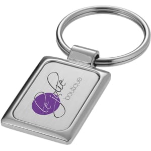 A rectangular silver keyring featuring a logo, with a polished finish and a circular attachment loop.