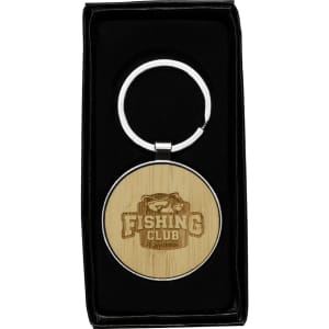 A circular keyring made of recycled zinc alloy with a bamboo disc, presented in a black box.
