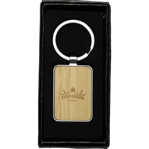 A rectangular keyring with a bamboo surface and a zinc alloy silver ring, presented in a black gift box.