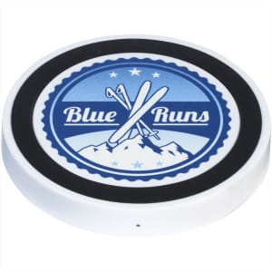 A wireless charging pad featuring a blue and white design with crossed skis and a mountain graphic, in white and solid black.