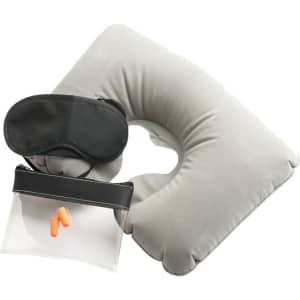 A grey travel neck pillow, black eye mask, ear plugs, and a clear toiletry bag.