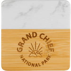 A marble and bamboo coaster featuring a logo and a smooth white marble top with a natural bamboo base.