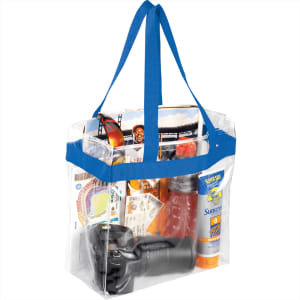 A clear tote bag with blue handles containing a drink bottle, sunscreen, a camera, snacks, and brochures.