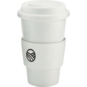 A ceramic coffee mug in white with a black logo and a silicone sleeve for grip.