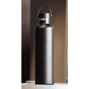 A drink bottle made of stainless steel, featuring a matte black finish and a carrying handle. It has a logo on the side.
