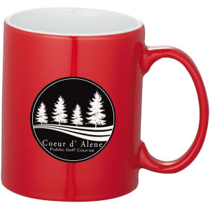 A red ceramic mug with a white interior and a logo featuring trees. Ideal for coffee or tea.
