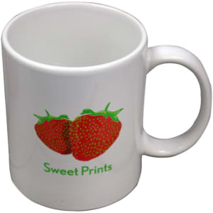 A white ceramic coffee mug featuring a graphic of strawberries and a logo, suitable for beverages.