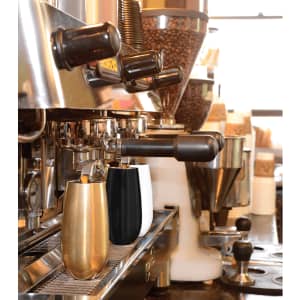 A drink bottle duo featuring a gold and a black vacuum champagne flute, situated on a café espresso machine.