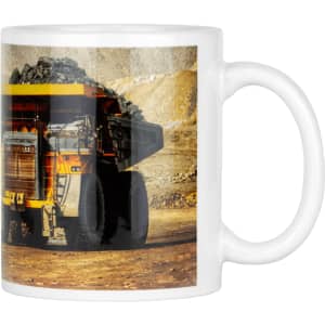 A coffee mug featuring a large yellow mining truck on a rocky background, with a white ceramic finish and a handle.