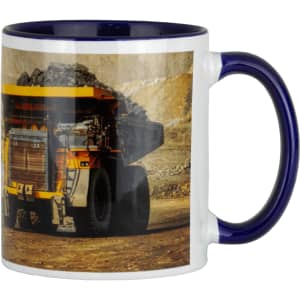 A ceramic mug featuring a blue handle and trim, with an image of a mining truck on one side.