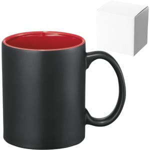 A ceramic mug in black with a red interior, accompanied by a plain white box.
