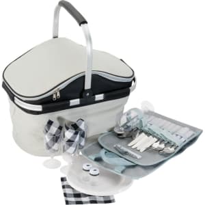 A grey and black picnic carry bag with cutlery, plates, glasses, napkins, and salt and pepper shakers arranged beside it.
