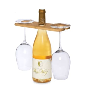 A wine bottle carrier with a bamboo handle, featuring two clear glasses. The bottle is white wine labelled "Chateau Mas Neuf".