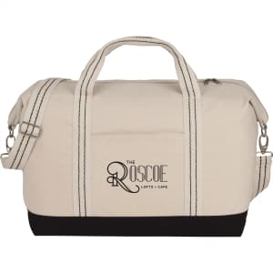 A cotton canvas duffel bag in cream with black accents, featuring handles and a detachable shoulder strap.