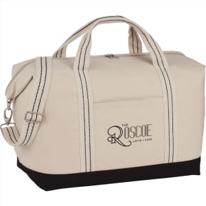 A cream canvas duffel bag with black accents and dual handles, featuring a logo on the side.