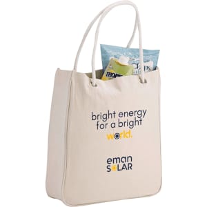 A cream-coloured tote bag with rope handles, featuring a branding logo and a pouch of snacks inside.