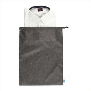 A grey toiletry bag containing a neatly folded white shirt. The bag features a drawstring closure and a logo.