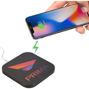 A black wireless charging pad with dual outputs, featuring a logo, and a phone being charged on top.