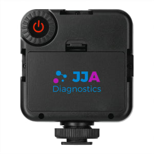 A portable video light in black with a power button and a branded logo on the front.