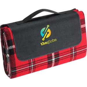 A red and black checkered picnic rug neatly folded with a black handle and a branding logo on the cover.