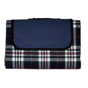 A picnic rug featuring a tartan pattern in navy blue, white, and red, with a solid navy flap and a branding logo.