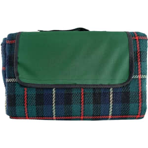 A folded picnic rug featuring a green top and a plaid pattern in blue, red, and cream colours. It has a carrying handle and a logo.