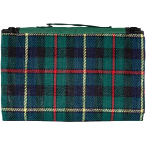 A green and black tartan picnic rug, folded with a carry handle, featuring red and yellow grid lines.