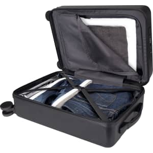 A wheeled black cabin trolley with an open lid, showcasing neatly packed clothes and a towel inside.