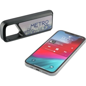 A Bluetooth speaker in black alongside a smartphone displaying a music app interface. The speaker has a logo.