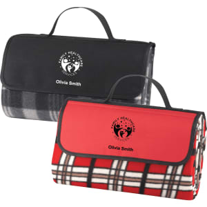 Two folded picnic rugs, one in black and grey checkered pattern, the other in red and black checkered pattern, featuring branding.